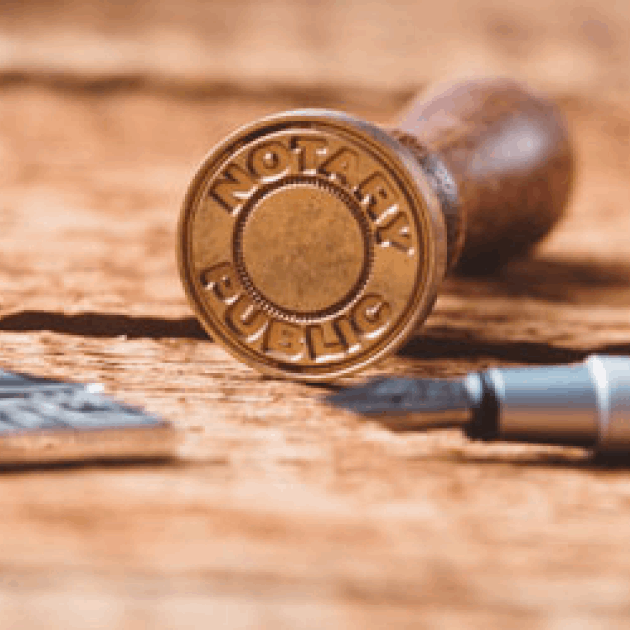 Close-up of round metal Notary seal stamp on wooden table