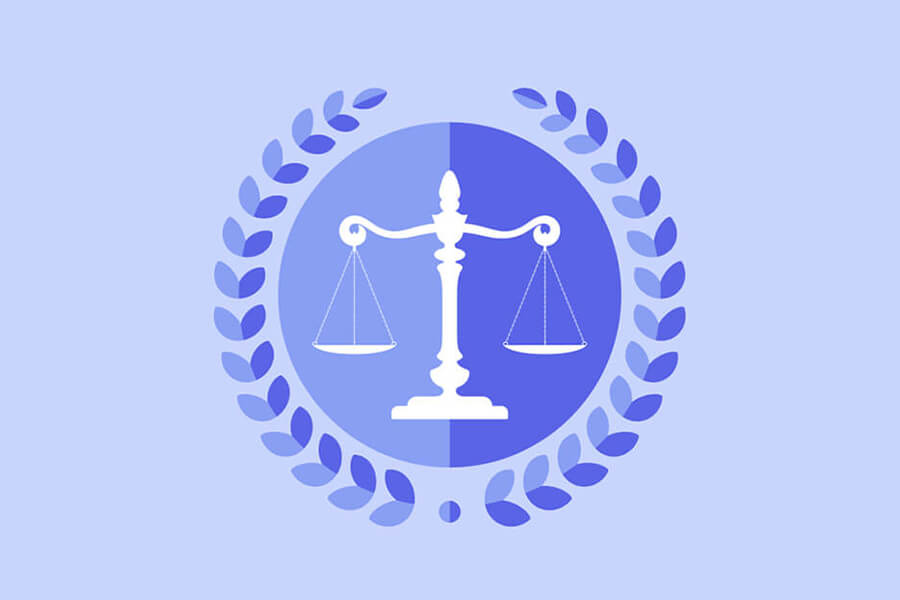 A scale of justice within a blue circle, surrounded by a laurel wreath