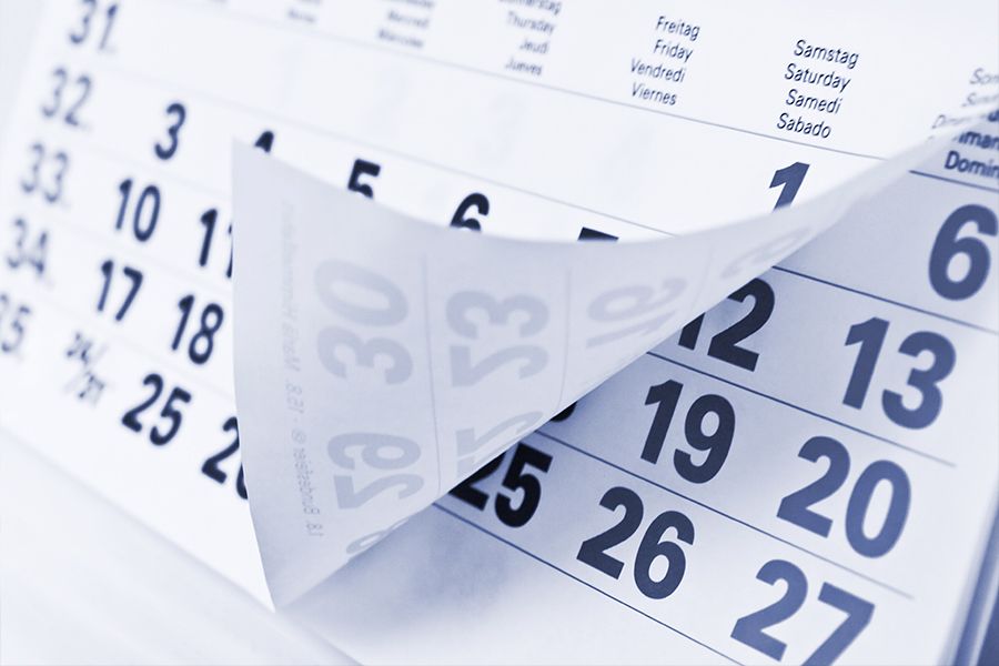 A close-up of calendar pages being flipped, showing numbered dates.