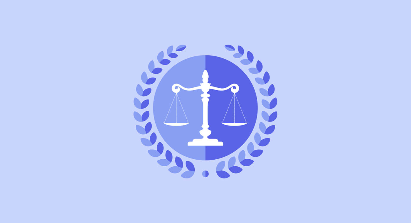 A scale of justice within a blue circle, surrounded by a laurel wreath